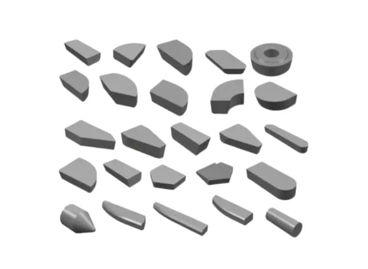 Assortment of tungsten carbide cutting inserts and tips in various shapes for machining and tooling applications.