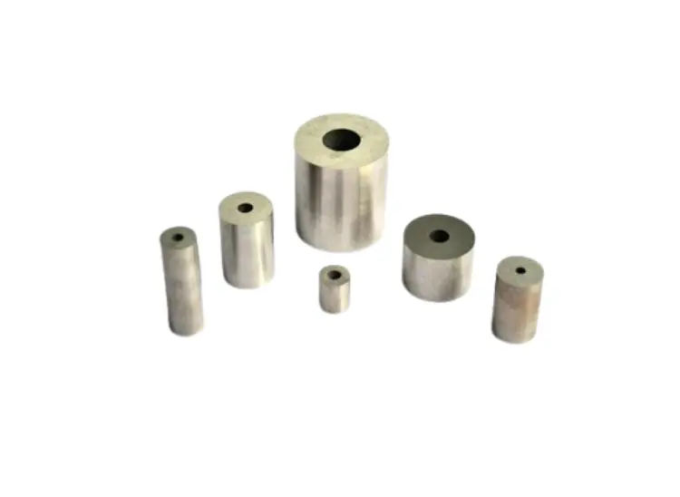 Group of seven cemented tungsten carbide punches and die nibs of various sizes.