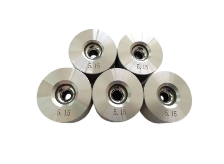 A group of six cemented carbide die cores (nibs) with a polished forming bore.