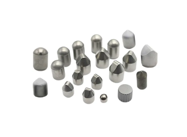 Assortment of tungsten carbide buttons and tips in various shapes (conical, domed, chisel).