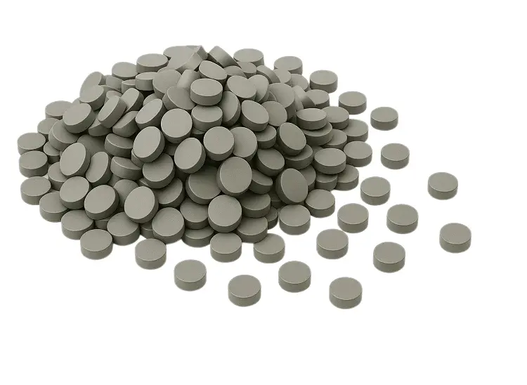 A pile of unfinished tungsten carbide blanks, or pills, representing raw material ready for sintering and machining into final wear parts.