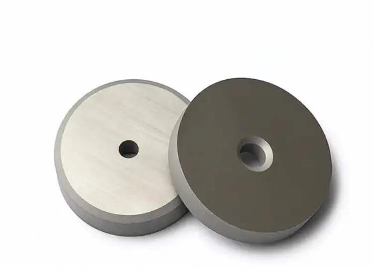 Two sintered tungsten carbide discs, showcasing the high-quality finish of our precision-ground components.